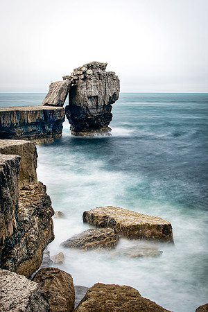 Waves crashing on the rocks below Pulpit Rock at Portland in Dorset.