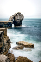 Waves crashing on the rocks below Pulpit Rock at Portland in Dorset.
