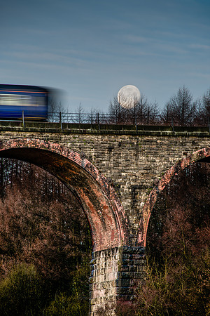The train crosses Entwistle Viaduct as the supermoon moon is setting behind.