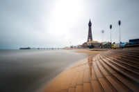 Long exposure image of steps down to the sea infront of Blackpool Tower and North Pier.