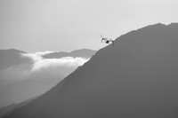 Black and white image of a Military plane flying across mountains of the Lake District.