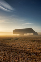 Sunrise on a misty morning lights up the wheat and the farmers barn in Sixpenny Handley.