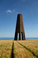 Tracks in a field of wheat at the base of Daymark Tower in Devon.