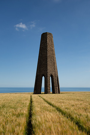 Tracks in a field of wheat at the base of Daymark Tower in Devon.