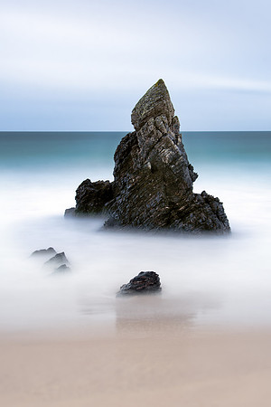 Long exposure image of Beach rock formations on Durness Beach at Sango Bay in Scotland with waves crashing.