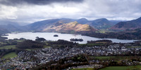 From Lattrigg sunshine lights up Catbells next to Derwentwater and Keswick on a moody, stormy day in Cumbria.