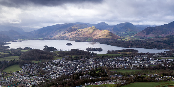From Lattrigg sunshine lights up Catbells next to Derwentwater and Keswick on a moody, stormy day in Cumbria.
