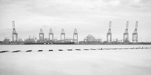 Long exposure of birds on sea defences and a boat unloading at Liverpool Docks.