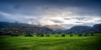 Sunset at Castlerigg Stone Circle with cloud covering Helvellyn mountains on a stormy day.