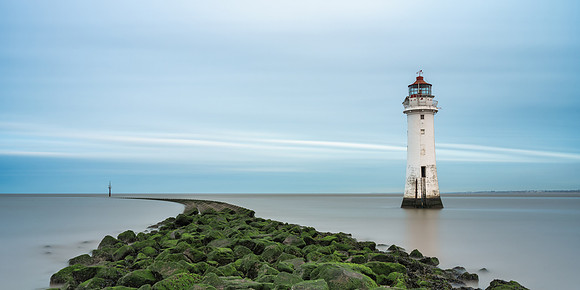 Long exposure image of Curved sea defenses and New Brighton Lighthouse near Liverpool.