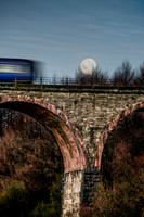 The train crosses Entwistle Viaduct as the supermoon moon is setting behind.