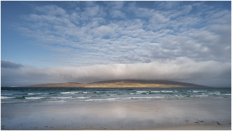 Taransay with waves an its own cloud halo from Luskentyre beach, Isle of Harris, Scotland.