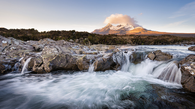 Water crashing over the Sligachan Falls at the Back Cuillin Mountains at sunrise on a winter's day.
