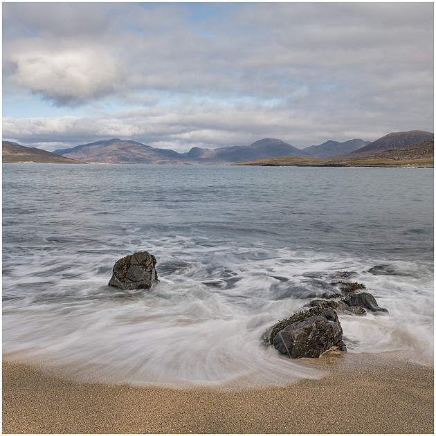 Incoming waves fan out across the coarse sand at Bagh Steinigidh, Isle of Harris, Scotland.