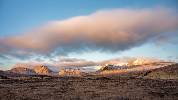 Sunrise lights up the snow covered Black Mountains on Rannoch Moor in Scotland.
